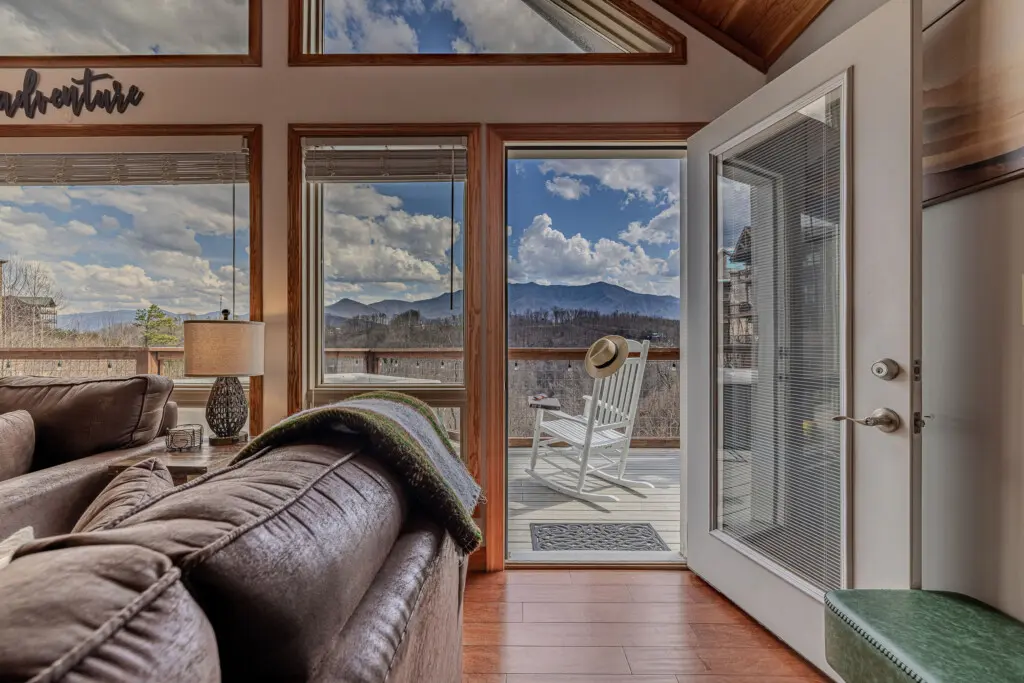 Glass deck doors opening to private rocking chair porch with panoramic Smokies views