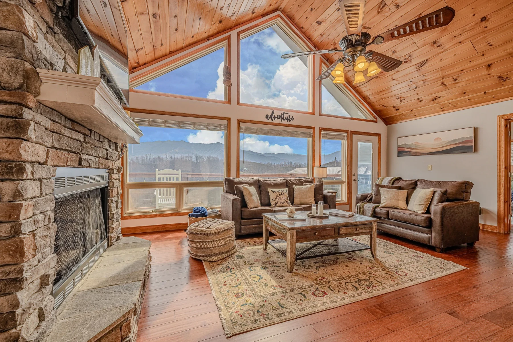 Modern living room with stone fireplace and mountain views at Summit View Lodge Gatlinburg