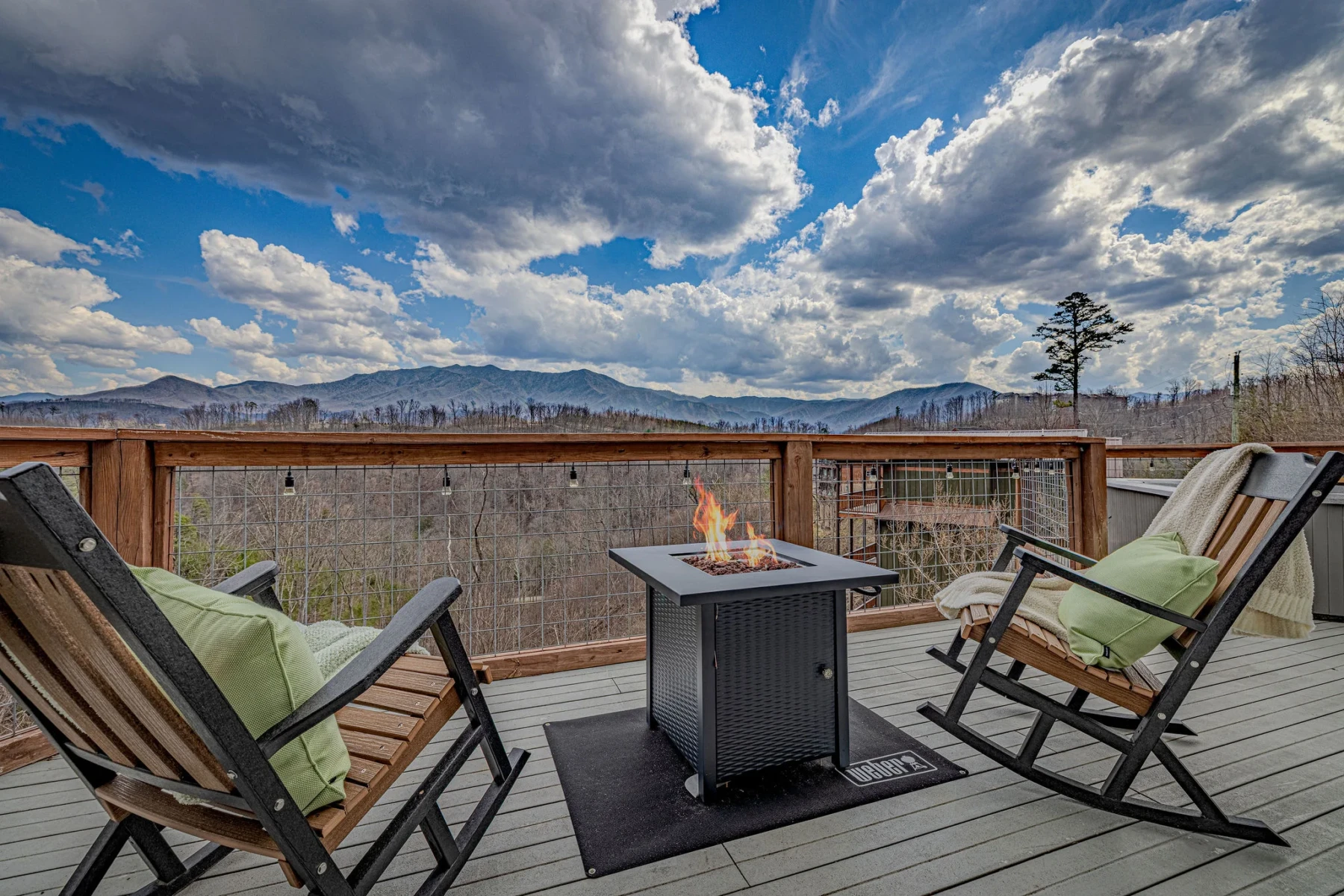 Covered mountain deck with fire pit and rocking chairs, a rainy day activity option at Summit View Lodge Gatlinburg