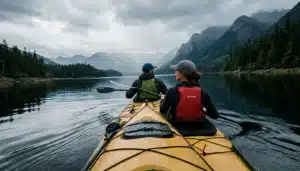 Two paddlers in a tandem kayak on calm water, kayaking near Gatlinburg on a misty Tennessee lake